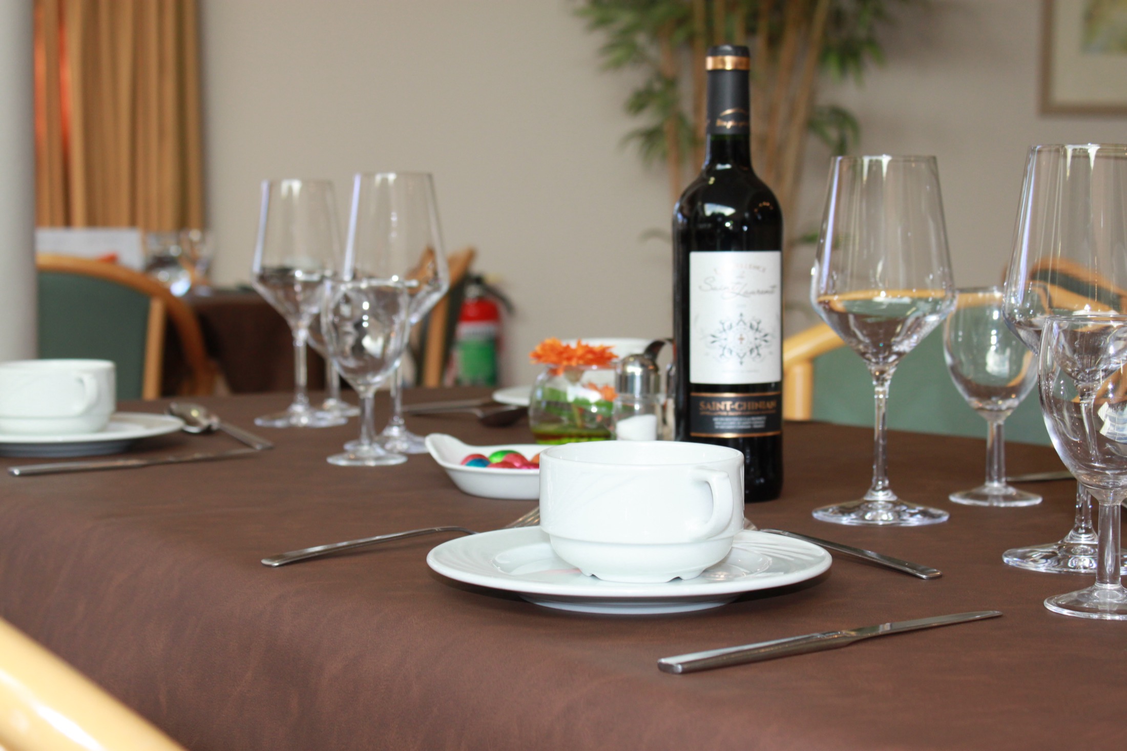 Bouteille de vin et verres dressés sur une table à Ter Korbeke